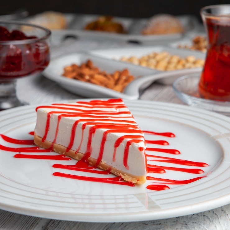 side-view-delicious-dessert-plate-with-tea-nuts-fruit-jam-white-wooden-background_176474-3893